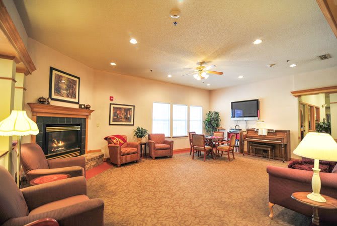 A cozy living room with comfortable seating, a fireplace, and a television.