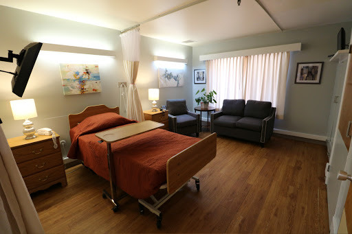 A comfortable and well-lit hospital room featuring a patient bed and seating area.