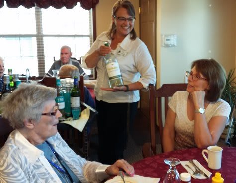 A group of people enjoying a celebration with wine at a restaurant.