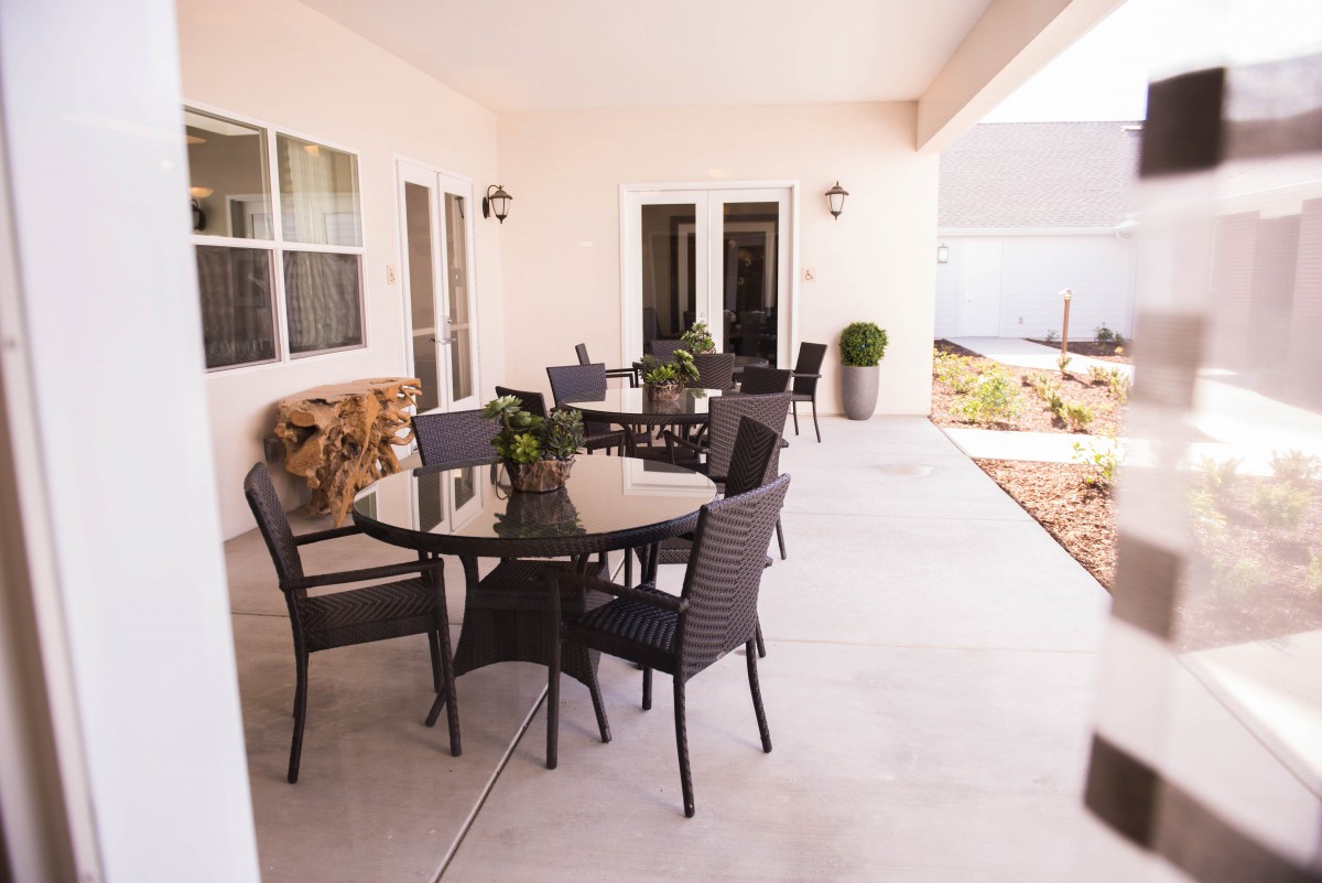 A spacious patio with outdoor seating and a table, set in a garden area.