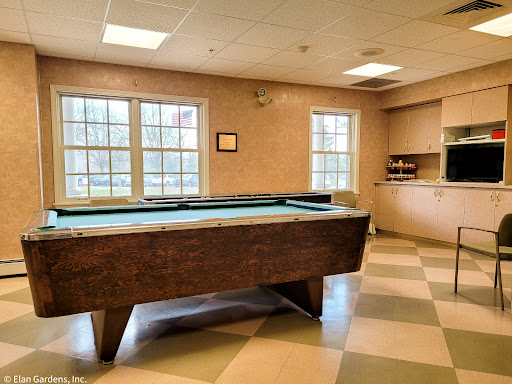 A cozy recreational room featuring a pool table and ample natural light.