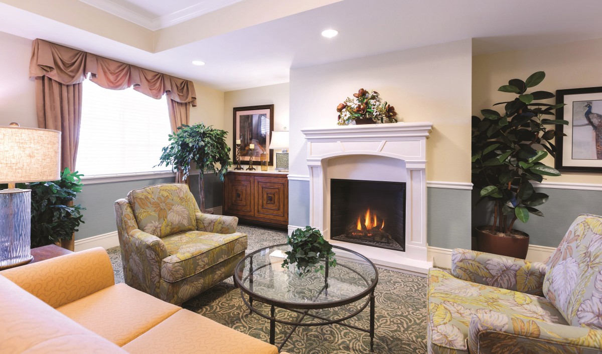 A cozy living room featuring a fireplace, armchairs, and elegant decor.