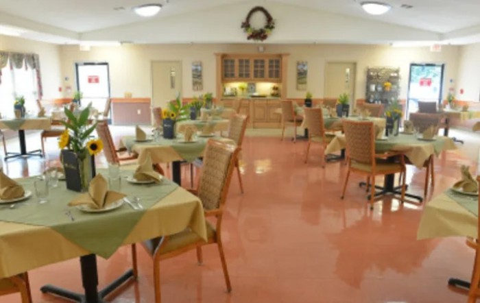 An empty dining area with neatly arranged tables and chairs, featuring a welcoming interior design.