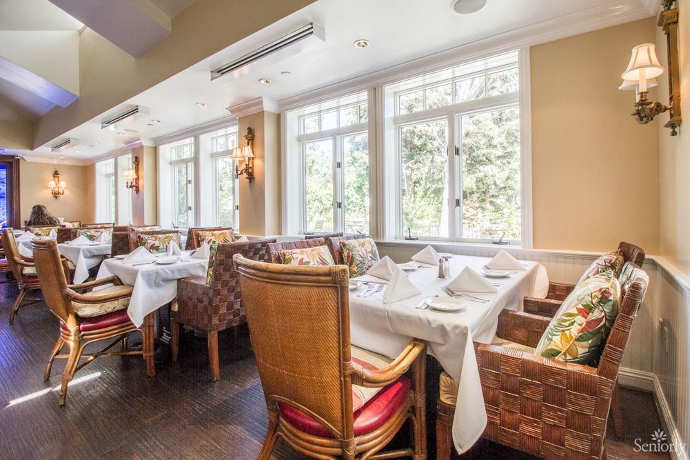 A well-lit restaurant interior with neatly set tables and comfortable seating.