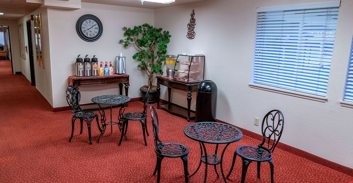 A cozy indoor cafe area with small tables and a beverage station.