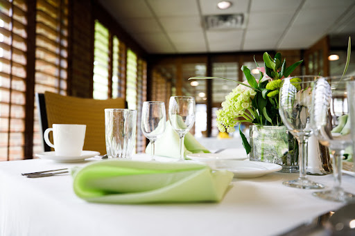 A beautifully arranged table setting featuring a green napkin and fresh flowers, creating an inviting dining atmosphere.