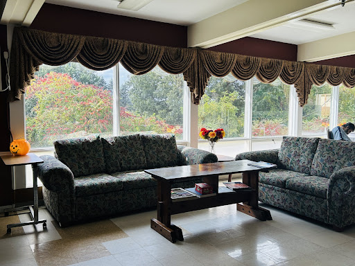 A cozy living room featuring elegant couches, a central coffee table, and large windows adorned with stylish curtains.