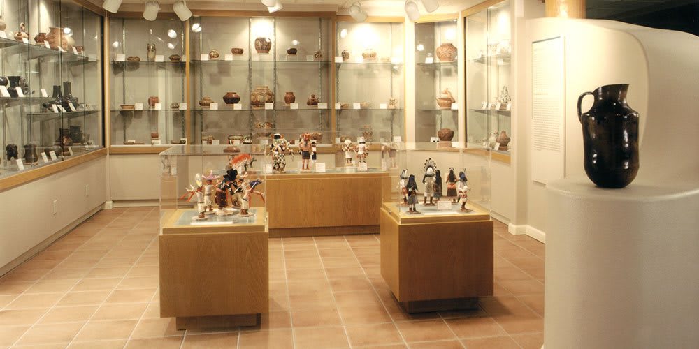 A museum exhibit showcasing various artifacts, including pottery and sculptures, displayed in glass cases.