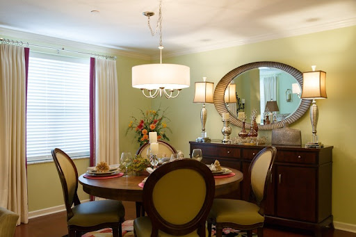 A cozy and elegantly designed dining room featuring a round table, comfortable chairs, and stylish lighting.