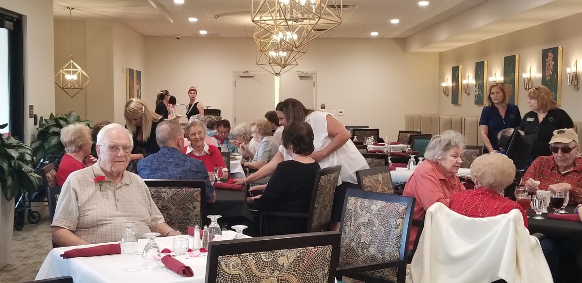 A group of people enjoying a dining event in an elegantly decorated room.