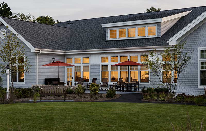 A cozy house with a spacious backyard and patio set in the evening light.