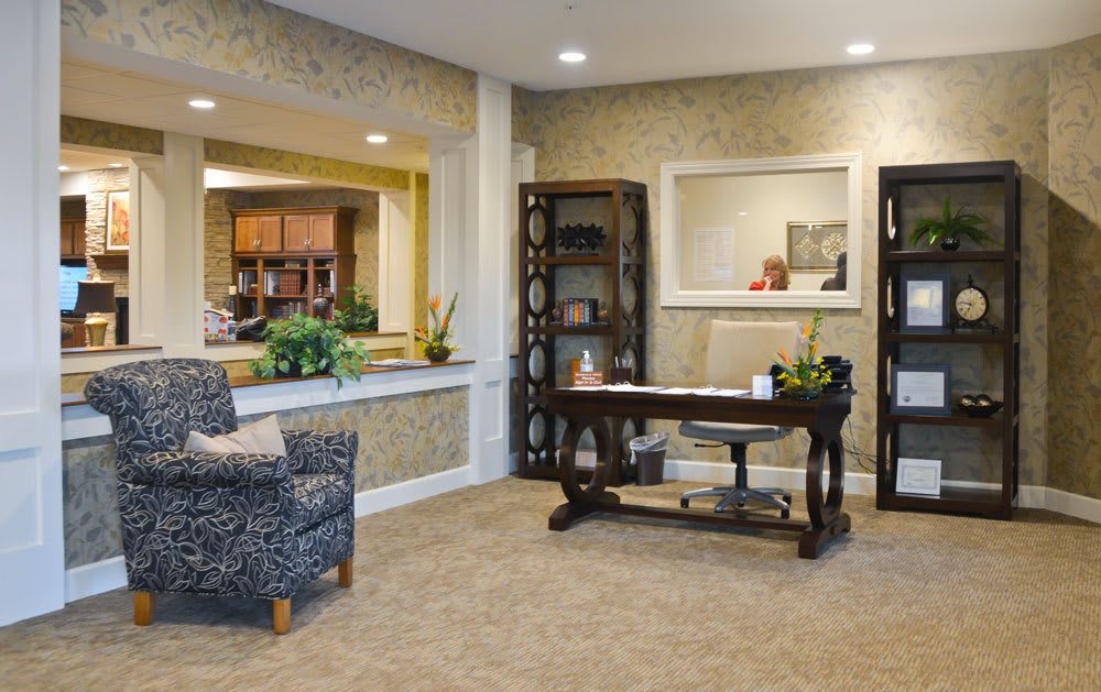 A cozy office space with a desk, bookshelf, and comfortable seating.