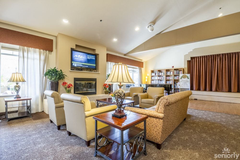A spacious living room with comfortable sofas, a large television, and elegant decor.