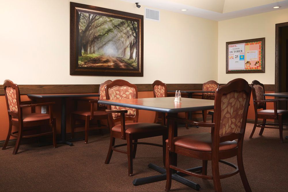 A cozy dining area with elegant chairs and a nature-themed painting on the wall.