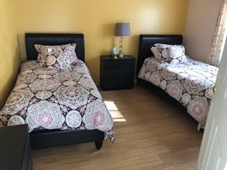 A cozy bedroom with twin beds and a shared nightstand.