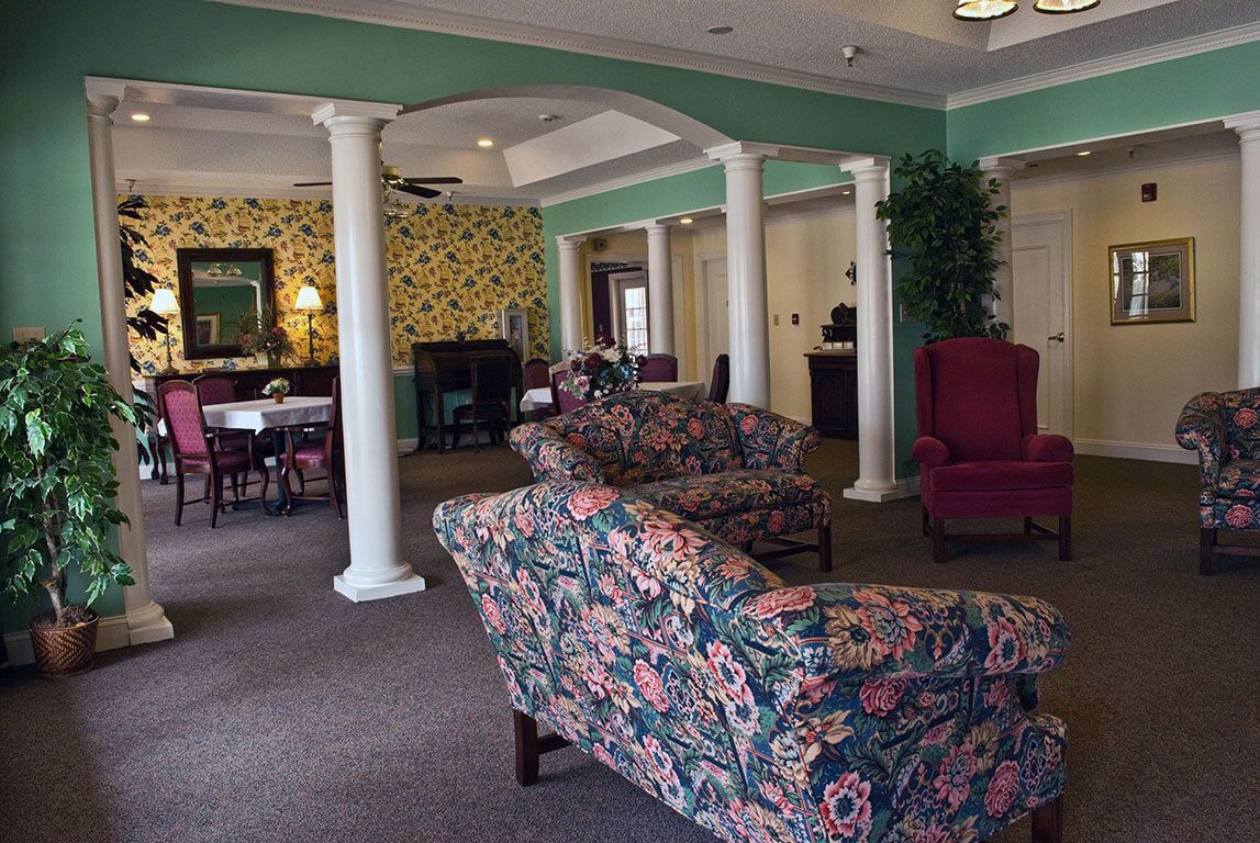 A traditional living room with floral patterned sofas and white columns.
