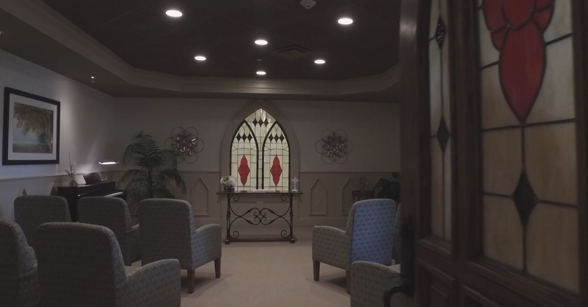 A serene chapel interior with stained glass and comfortable seating.