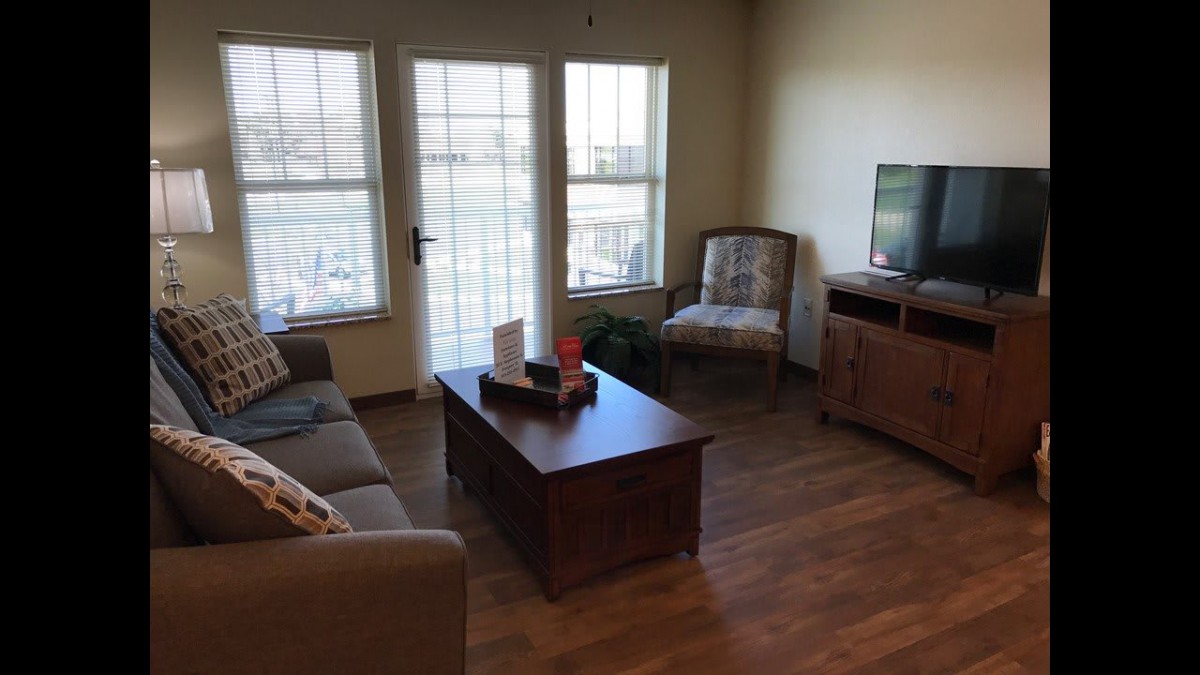 A cozy living room with a sofa, coffee table, and television.
