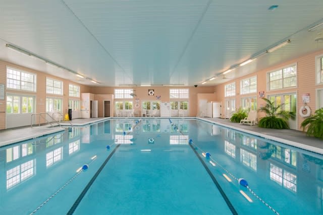 A spacious indoor swimming pool with clear water and natural lighting.