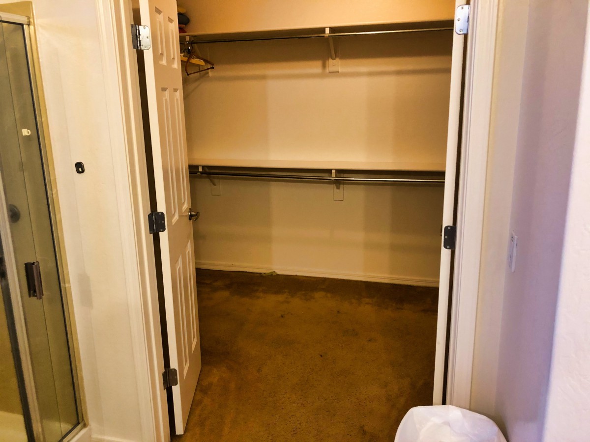 An empty closet with open doors and shelving for storage.