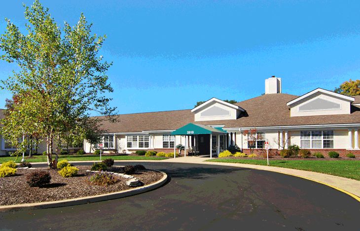 A residential building with a landscaped driveway and blue sky.