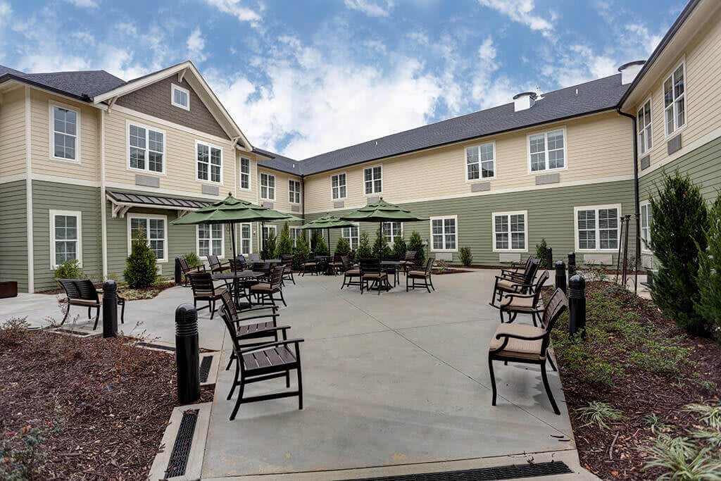 A peaceful patio area with chairs in a residential building's courtyard.