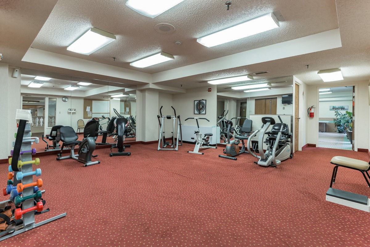 A well-equipped indoor gym with various exercise machines.
