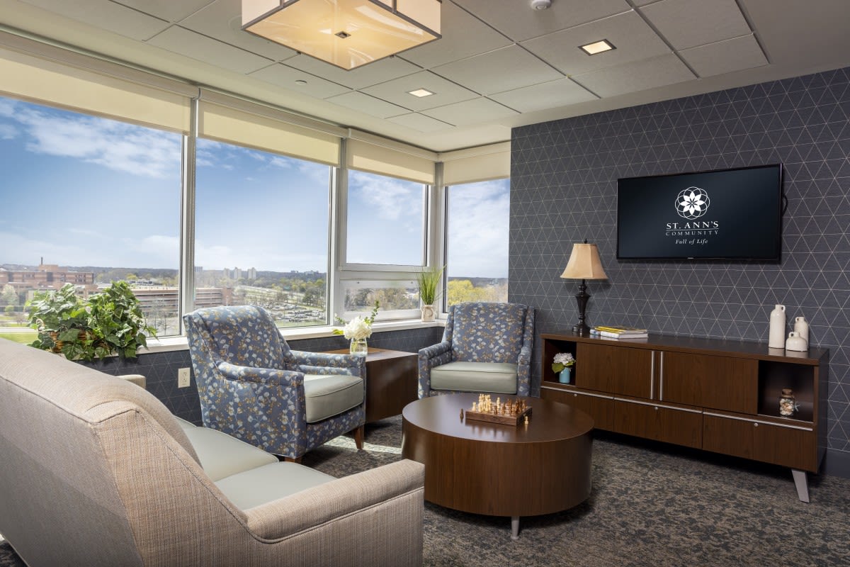 A modern office lounge with comfortable seating and a city view.