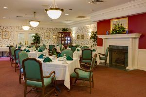 An elegant dining room set for guests, featuring neatly arranged tables and chairs with decorative lighting.