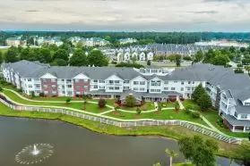 Aerial view of a residential complex near a lake in a suburban area.