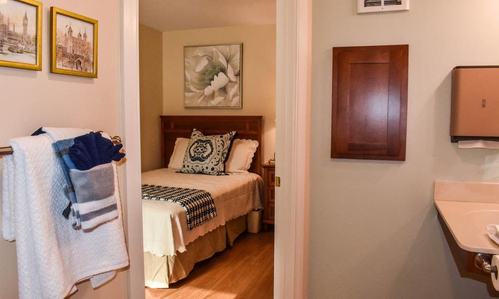 A cozy bedroom with a neatly made bed and decorative pillows.