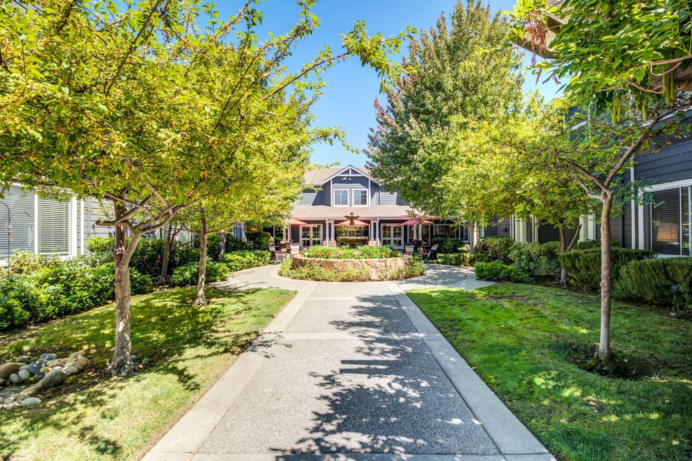 Beautiful residential home surrounded by lush trees and a well-maintained garden.