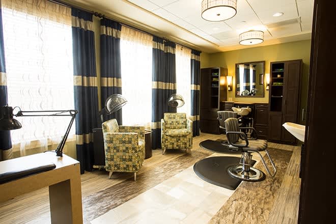 A modern salon interior featuring styling chairs, mirrors, and elegant decor.