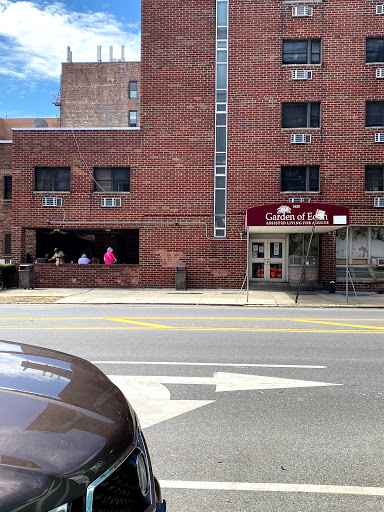 A view of a brick building featuring a restaurant with outdoor seating, captured on a sunny day.