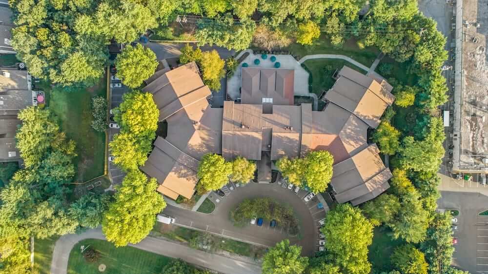 Aerial view of a building surrounded by lush greenery.