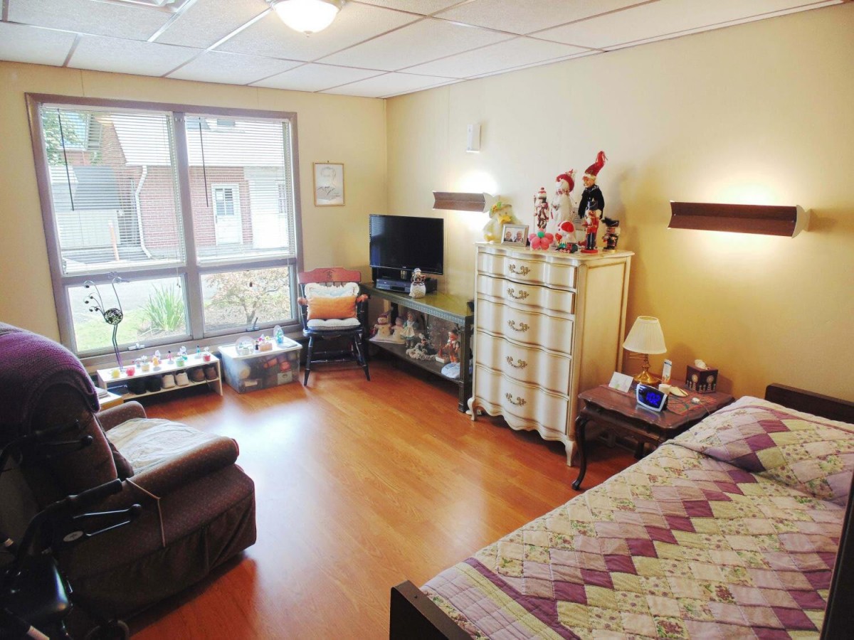 A cozy bedroom with comfortable furnishings and natural light from a large window.