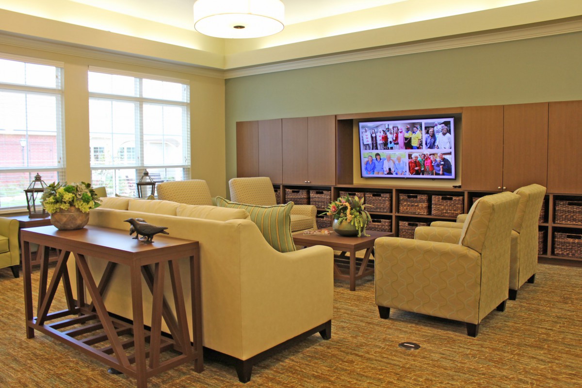 A modern lounge with comfortable seating and a large television.