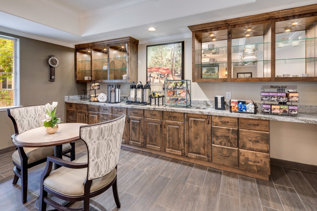 A modern kitchen with wooden cabinets and a cozy dining area.