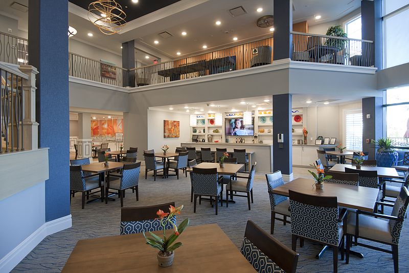 Modern cafe interior with multiple tables and chairs in an open space.