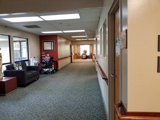 A view of a hospital hallway featuring a waiting area with seating.