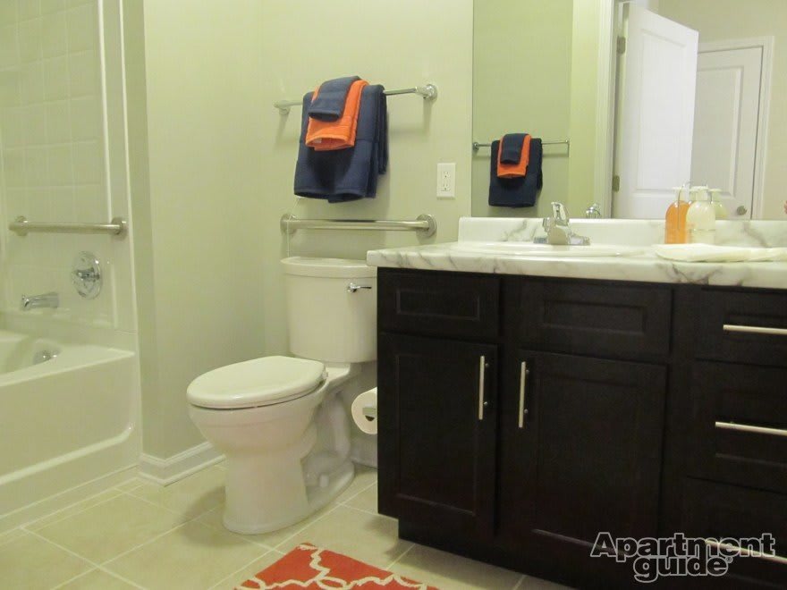 A well-organized bathroom with a sink, toilet, and decorative towels.