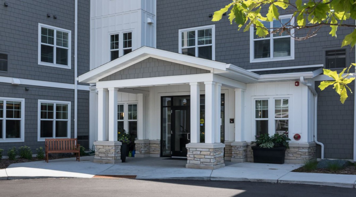 A modern building entrance with columns and large windows.