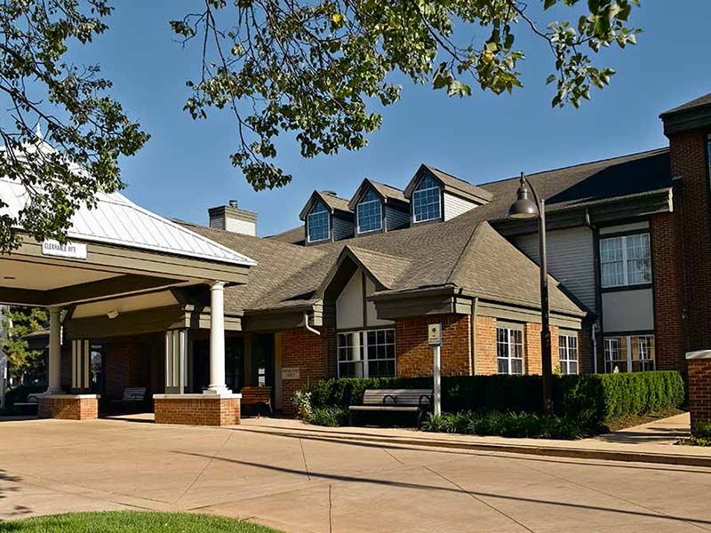A suburban residential building with a well-maintained exterior and surrounding greenery.