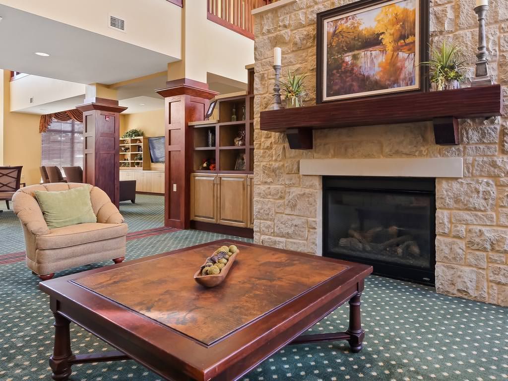 A cozy living room with a fireplace, artwork above the mantel, and comfortable seating.