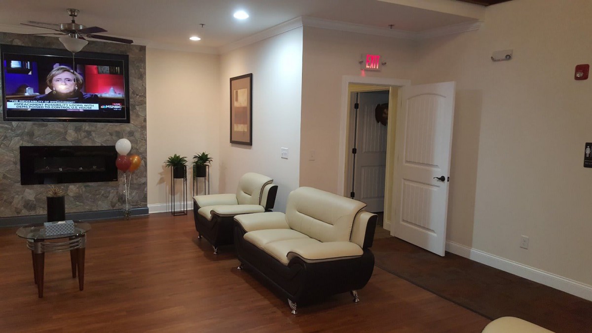 A cozy waiting room with modern furniture and wooden flooring.