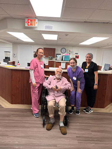A joyful moment shared between a patient and the caring nursing staff in a healthcare facility.