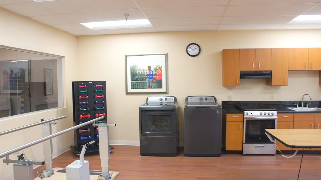 A room featuring a washer and dryer set with kitchen utilities and storage cabinets.