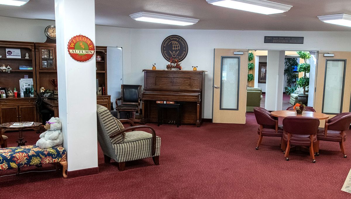 A cozy office lobby featuring a piano and comfortable seating.