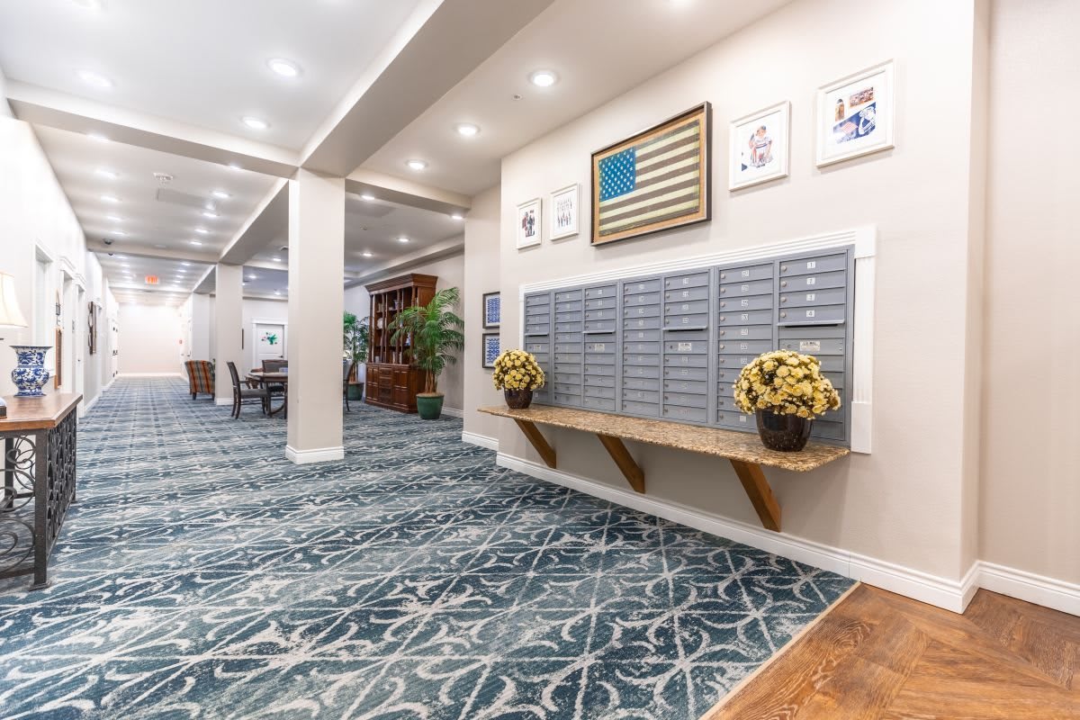 A well-lit lobby area with mailboxes, decorative plants, and artwork on the walls.