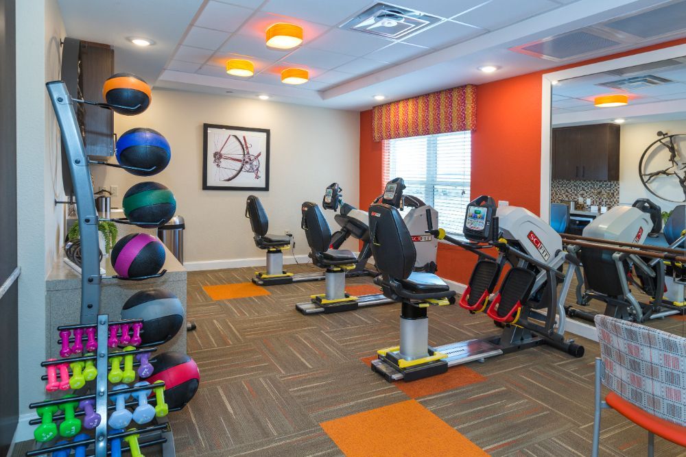 A modern gym with stationary bikes and a variety of fitness equipment.